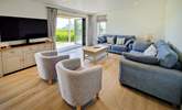 The ground floor is open plan with a beautifully styled sitting area, cosy sofas and Smart TV. - Thumbnail Image