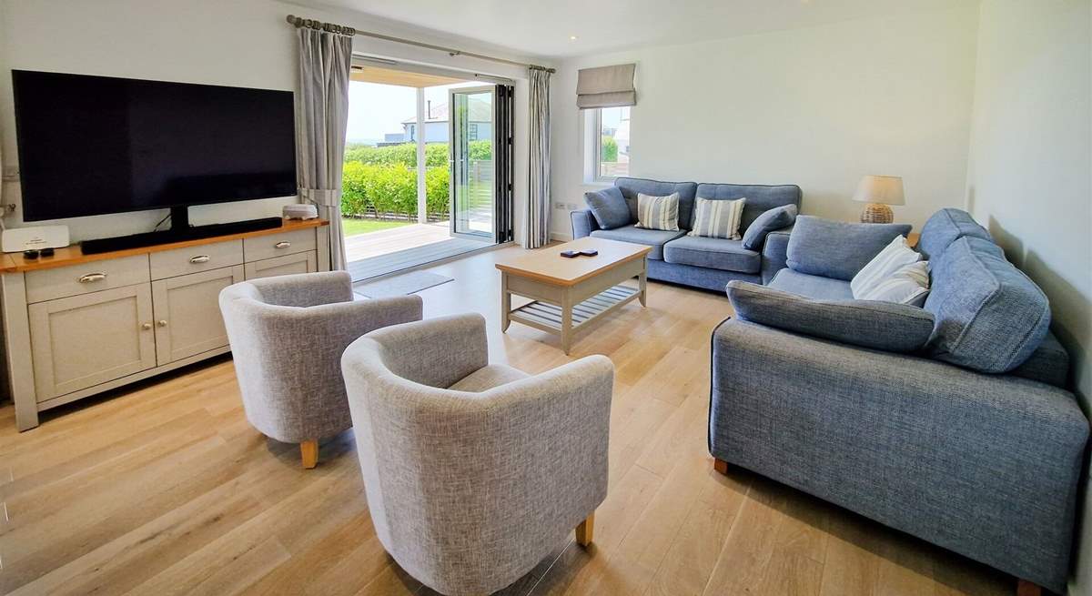 The ground floor is open plan with a beautifully styled sitting area, cosy sofas and Smart TV.