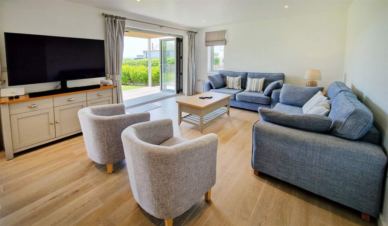The ground floor is open plan with a beautifully styled sitting area, cosy sofas and Smart TV.