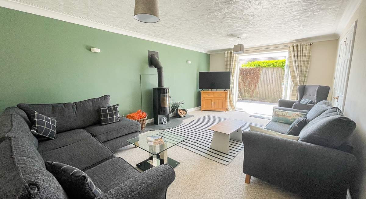 The sitting-room has cosy seating and a warming wood-burner for cooler days. 