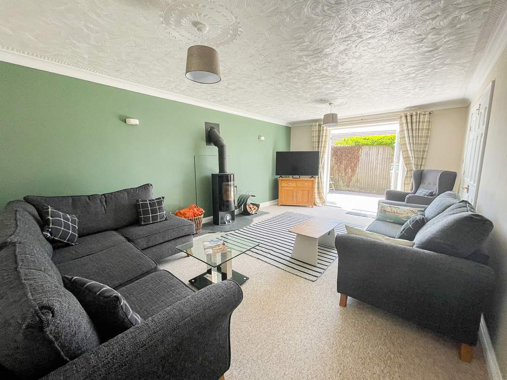 The sitting-room has cosy seating and a warming wood-burner for cooler days.