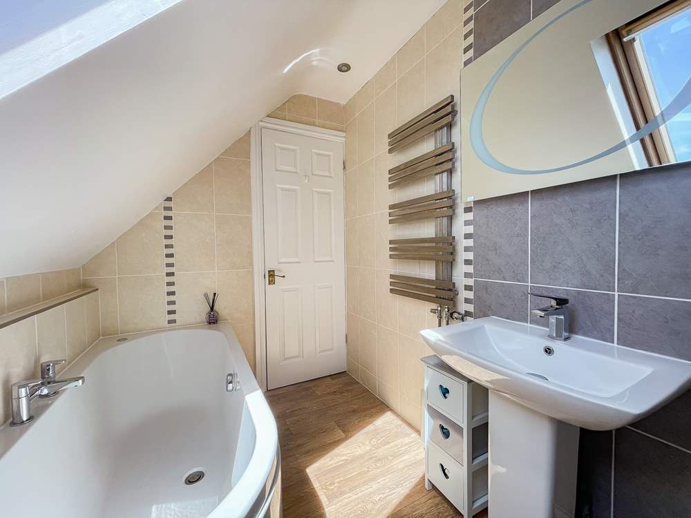 The family bathroom has a bath for a long soak after a busy beach day.