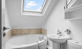 Enjoy a relaxing soak in the corner bath. - Thumbnail Image