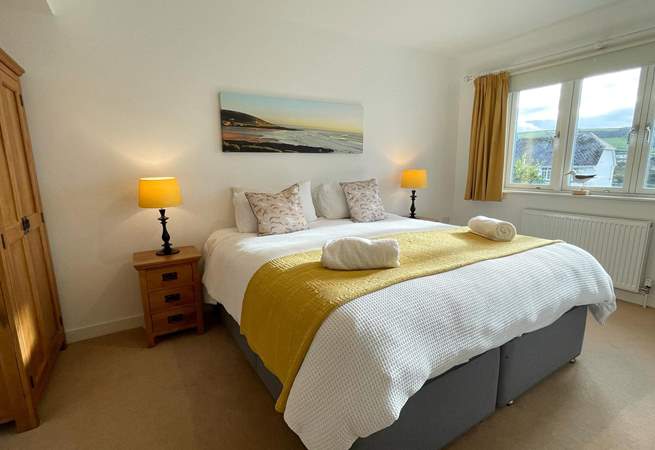 The main bedroom enjoys an ensuite and glorious views across to the beach.