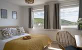 The main bedroom sits to the front of the house with views out across the coast and golden sands.  - Thumbnail Image