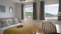 The main bedroom sits to the front of the house with views out across the coast and golden sands. 