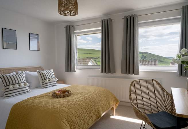 The main bedroom sits to the front of the house with views out across the coast and golden sands. 