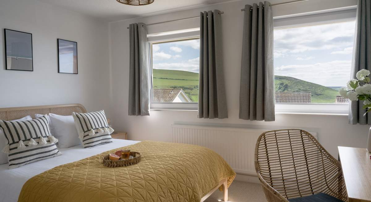 The main bedroom sits to the front of the house with views out across the coast and golden sands. 