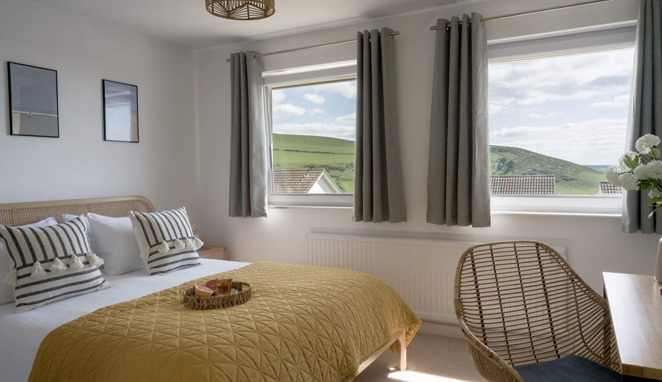 The main bedroom sits to the front of the house with views out across the coast and golden sands. 