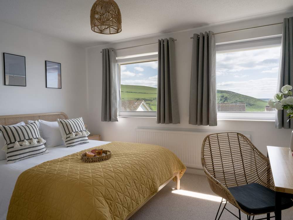 The main bedroom sits to the front of the house with views our across the coast and golden sands.