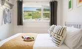 The bedroom to the back of the house offers a view of the garden and out across the fields. - Thumbnail Image