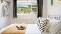 The bedroom to the back of the house has views of the garden and across the fields.