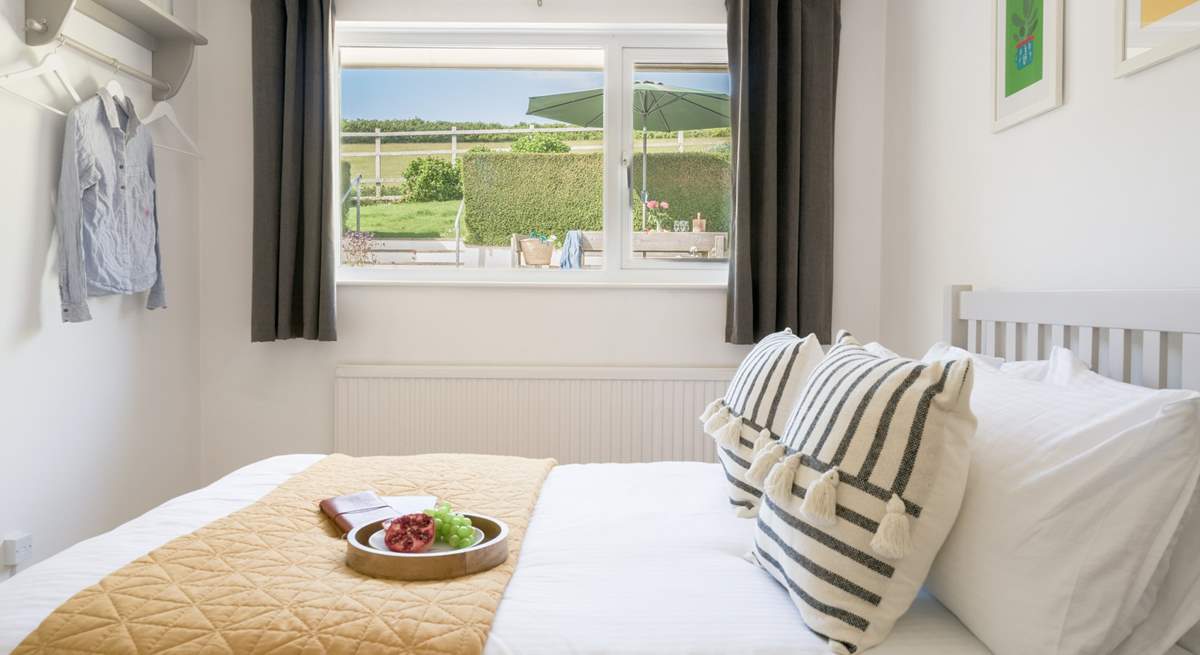 The bedroom to the back of the house offers a view of the garden and out across the fields.