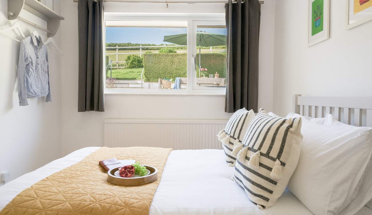 The bedroom to the back of the house has views of the garden and across the fields.