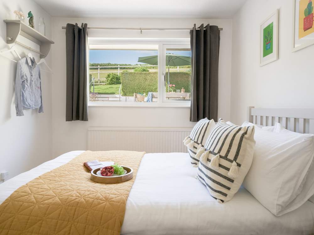 The bedroom to the back of the house offers a view of the garden and out across the fields.