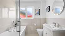 The family bathroom has a bath for a long soak after a busy beach day. 