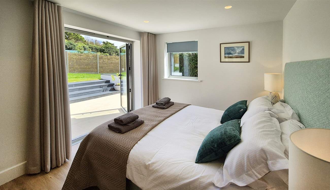 Beautiful bedroom 2 has double doors leading out to the garden.