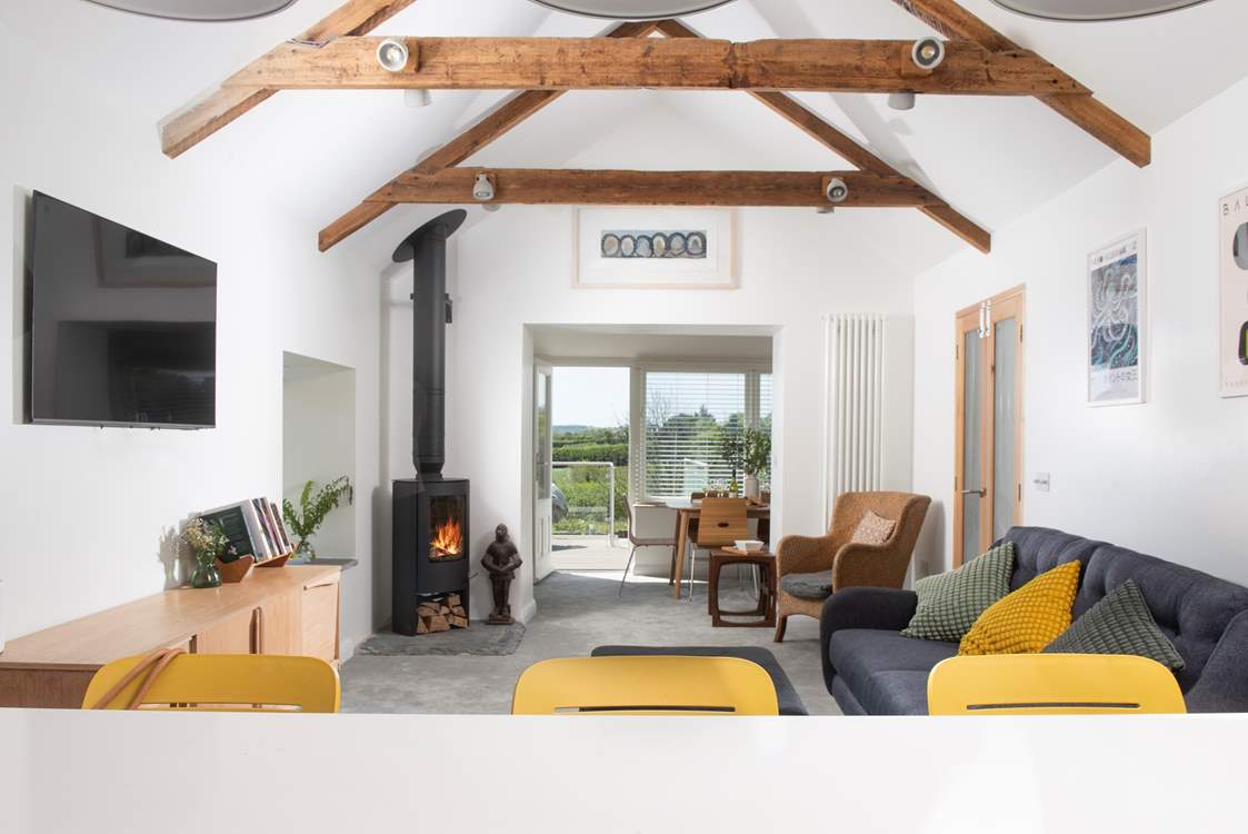 The open plan living area with rustic beams and a very cosy wood-burner.
