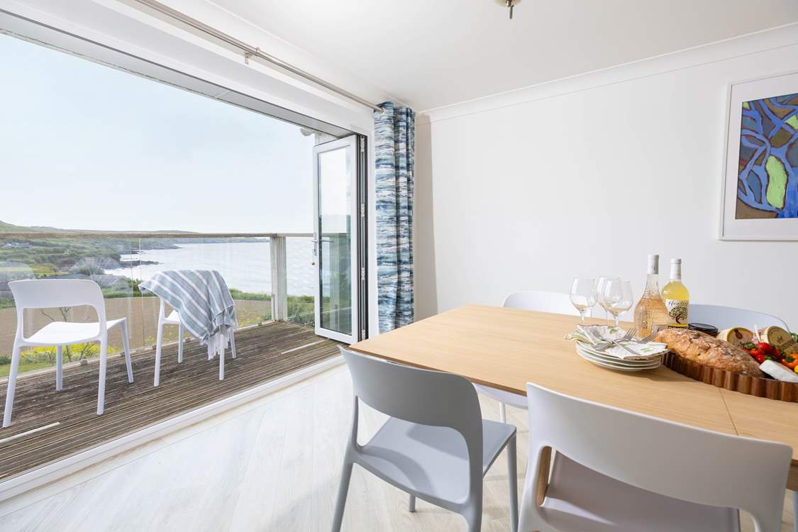 Sliding doors open onto a small balcony from the modern dining-room, providing a panoramic view of this beautiful coastline.