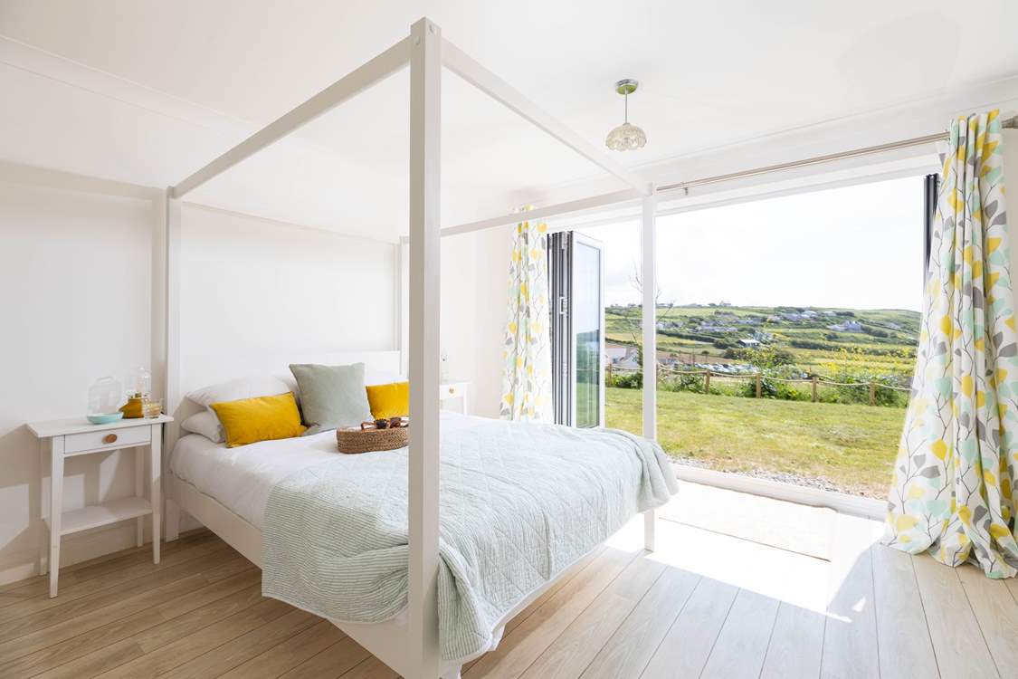 Heading downstairs, the main bedroom has a large en suite and doors that open directly into the garden and enjoys views of the sea below.