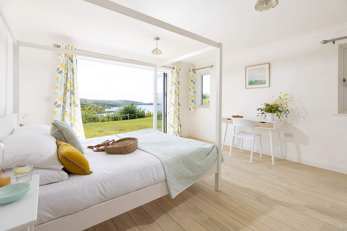 The main bedroom has bi-fold doors opening onto the garden and views over the stunning beach below.