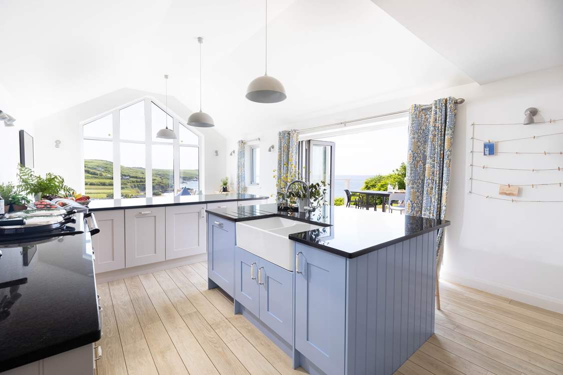 Bi-fold doors lead to a decked terrace overlooking the beach and gardens.