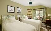 The twin bedroom has gorgeous linens and pretty padded headboards to really bring the 