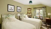 The twin bedroom has gorgeous linens and pretty padded headboards to really bring the 