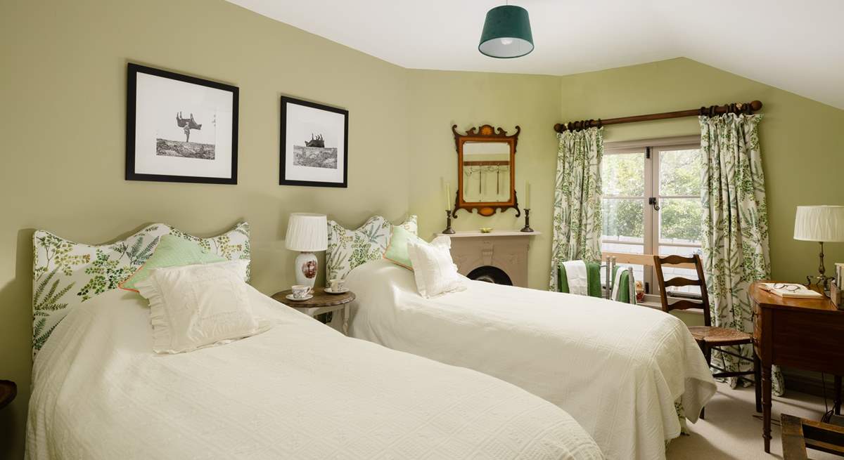 The twin bedroom has gorgeous linens and pretty padded headboards to really bring the 