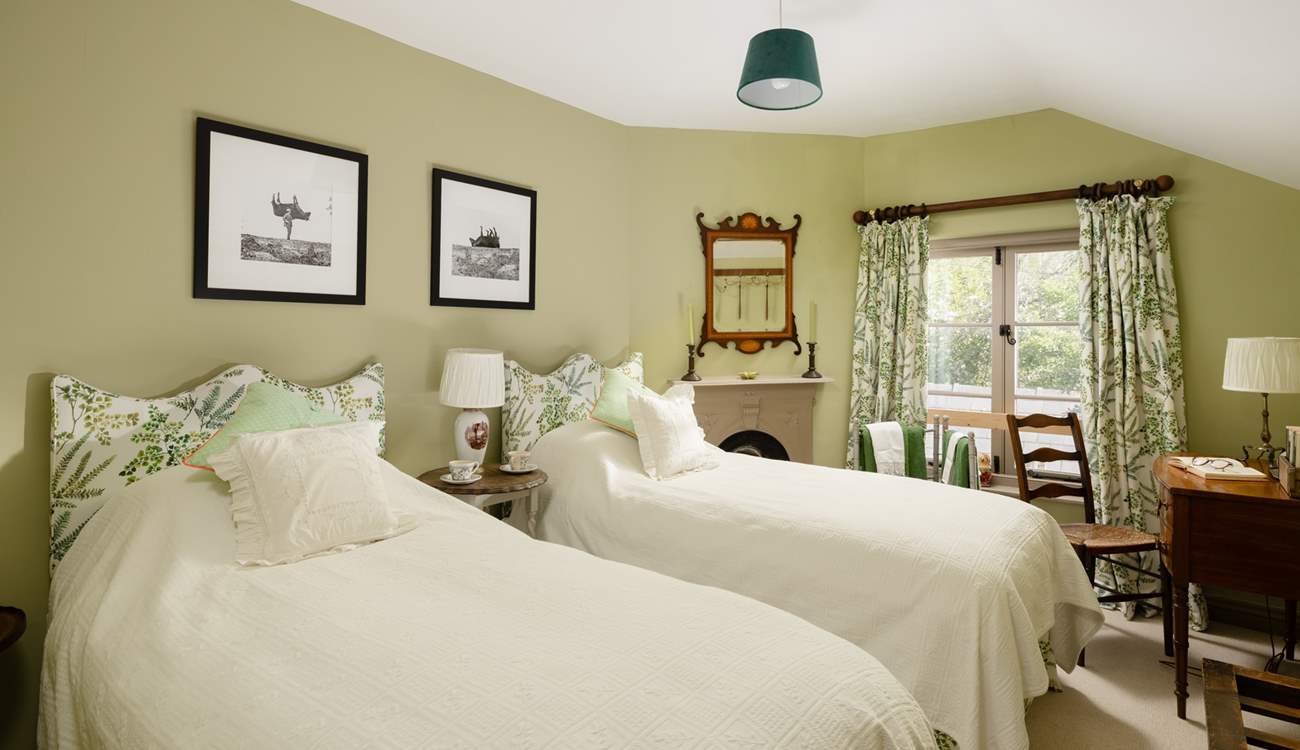 The twin bedroom has gorgeous linens and pretty padded headboards to really bring the 