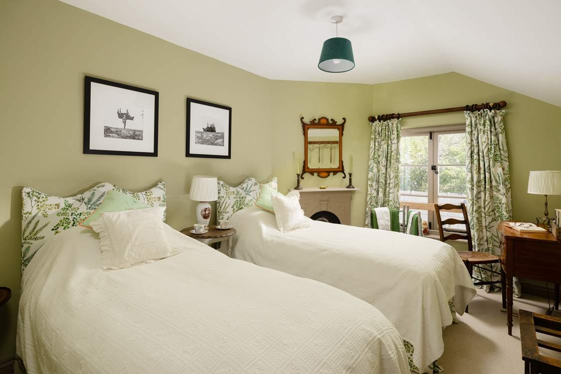 The twin bedroom has gorgeous linens and pretty padded headboards to really bring the