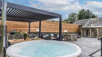 The outdoor cooking/dining and seating area complete with a wood-fired hot tub.