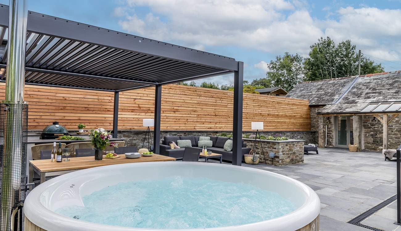 The outdoor cooking/dining and seating area complete with a wood-fired hot tub.