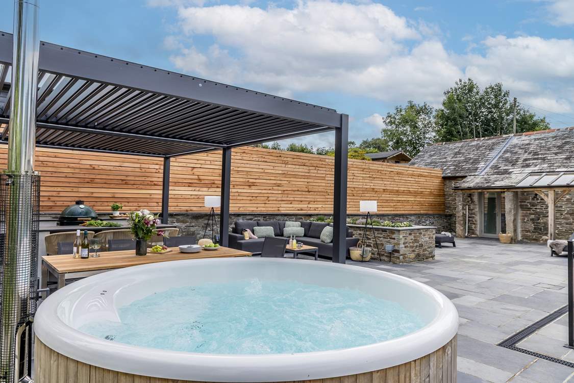 The outdoor cooking/dining and seating area complete with a wood-fired hot tub.