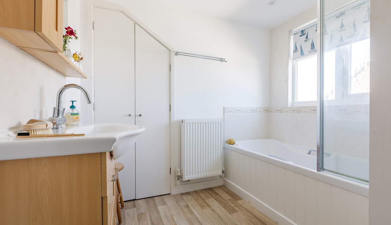 The upstairs bathroom is light and airy with privacy blind.