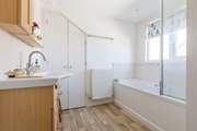 The upstairs bathroom is light and airy with privacy blind.