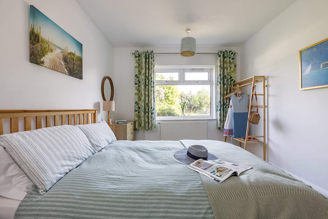 Relax and unwind in the light-filled downstairs bedroom, lovely views of the rear garden.
