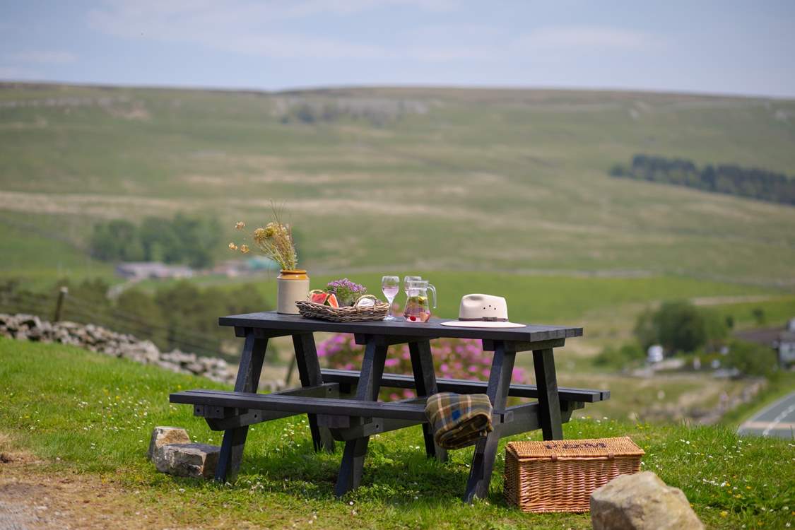 The garden table sits atop the garden and looks over the fields and hills.