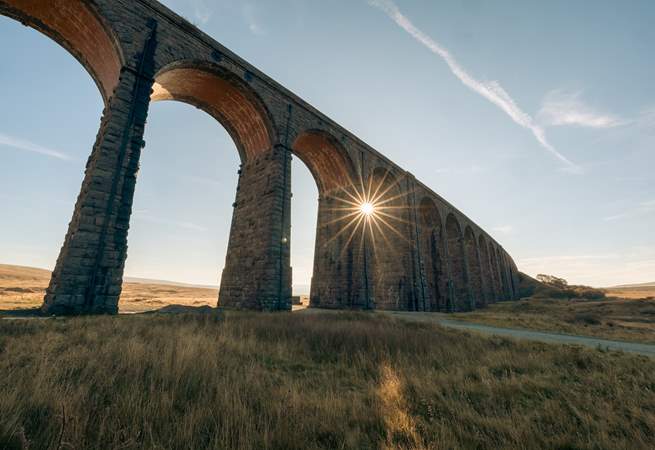 Ribblehead Viaduct with the evening sun shining through.