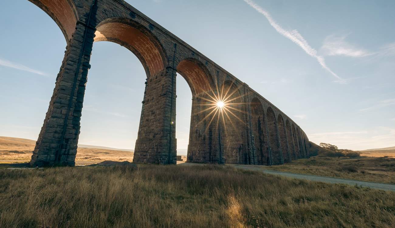 Ribblehead Viaduct with the evening sun shining through.