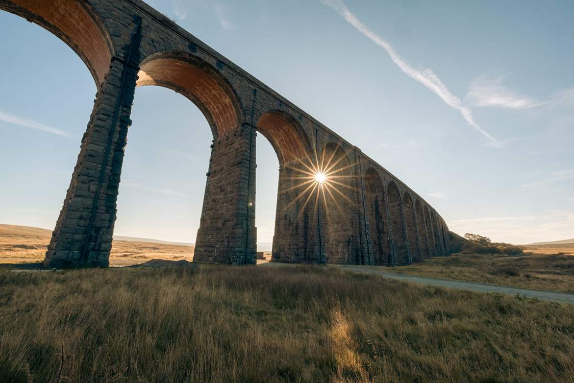 Ribblehead Viaduct with the evening sun shining through.