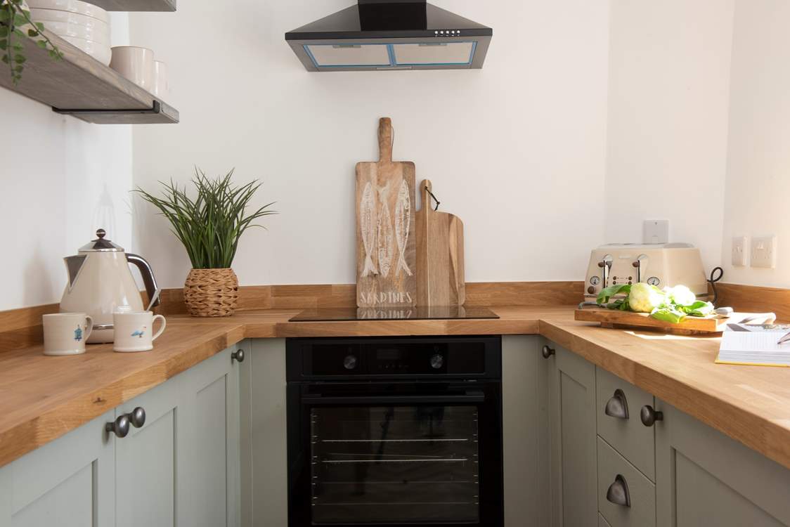 The charming galley kitchen is equipped with all the essentials.