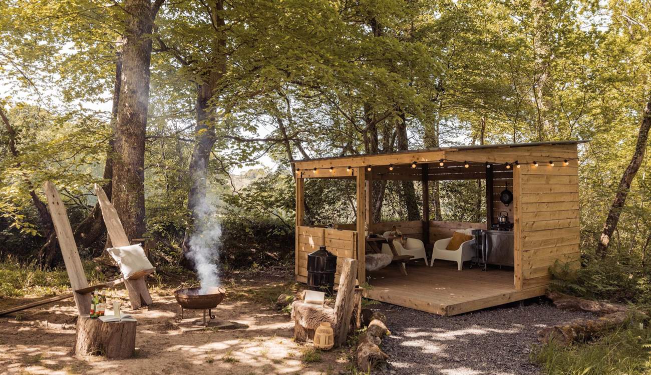 The dreamy alfresco space features a fire pit and undercover kitchen-diner.