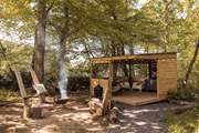 The dreamy alfresco space features a fire pit and undercover kitchen-diner.