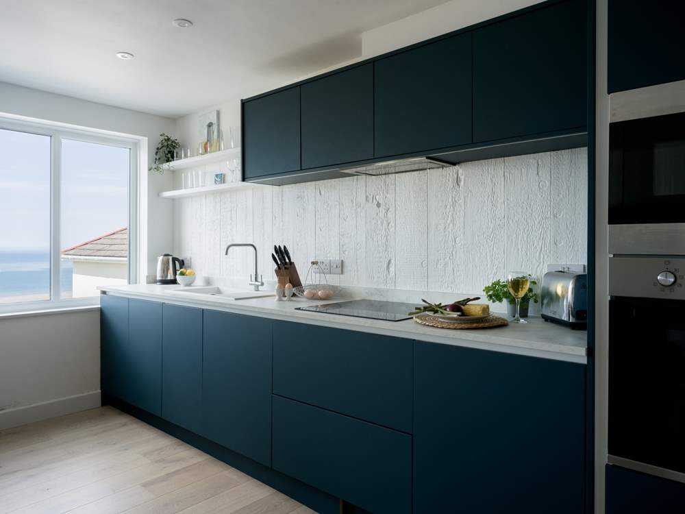 The fully equipped kitchen mirrors the blue of the ocean and sky.