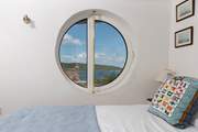 The innovative porthole windows frame the ocean view (coverings for night time are in situ).