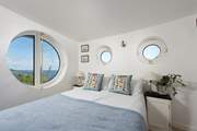 Porthole windows brings the boat shaped architecture together (bespoke coverings for night time are in situ).