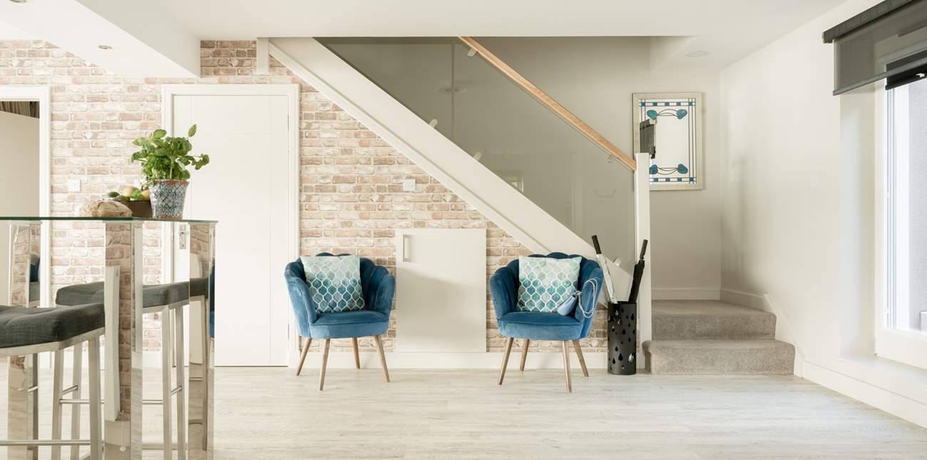 The staircase leads up to the first floor and the glass balustraded walkway.