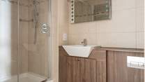 The family bathroom sits opposite the twin room offering a shower cubicle and bath.