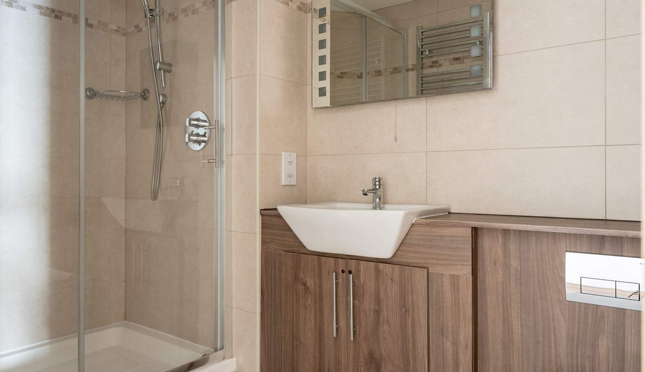 The family bathroom sits opposite the twin room offering a shower cubicle and bath.